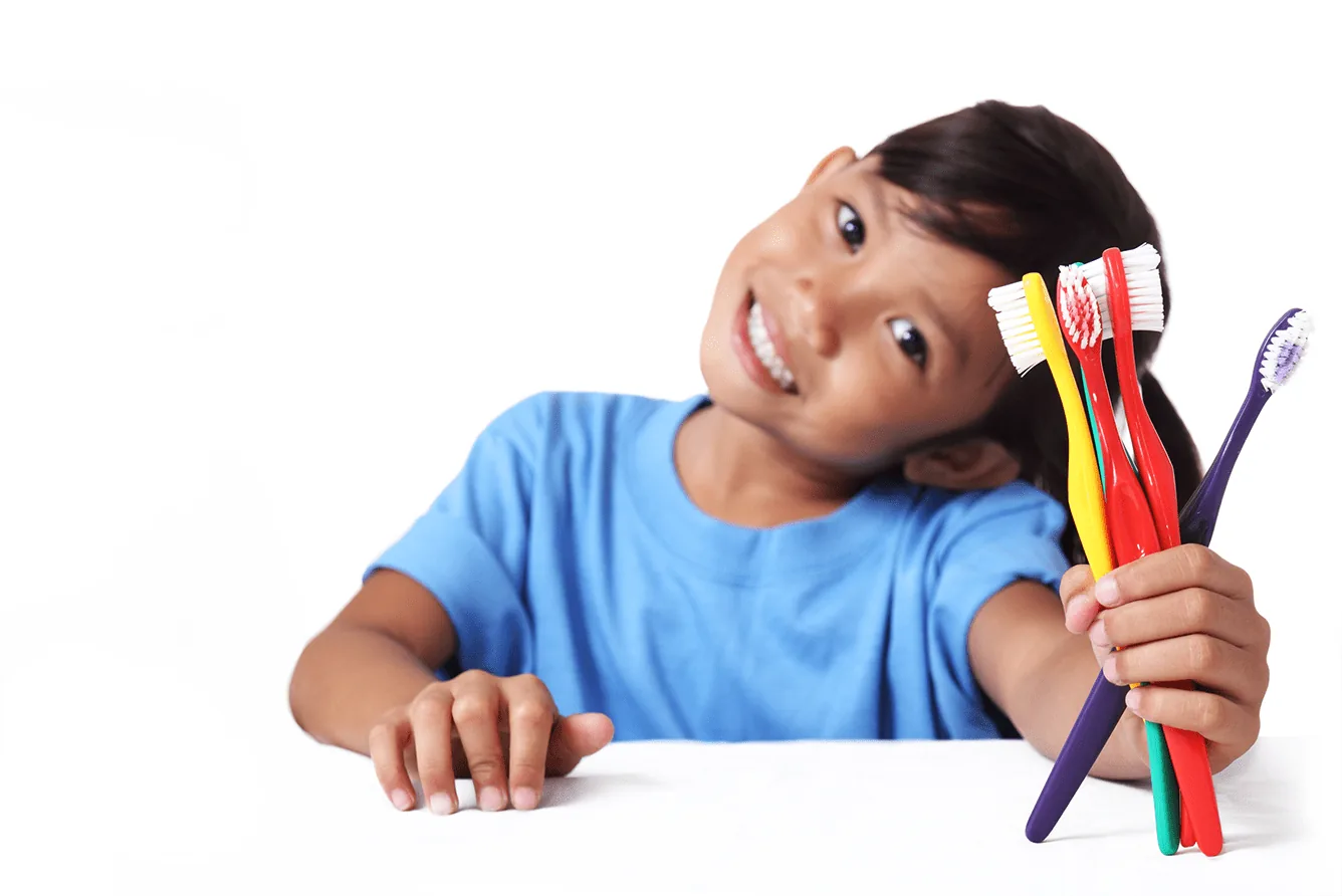 Child holding a bundle of toothbrushes